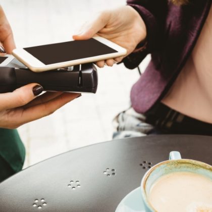 mastercard-mobilno-placevanje-1-Woman paying with mobile phone in cafe